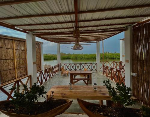 eine Veranda mit einem Tisch und Blick auf das Wasser in der Unterkunft Hostal Casa en la Ciénaga in San Onofre