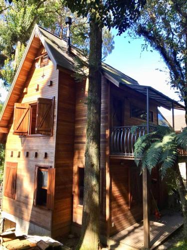 a house with a balcony on the side of it at Chalé Romântico - Gramado in Gramado
