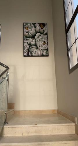 a picture hanging on a wall in a room at Al Ghadeer Maison Masfout in Sharīyah