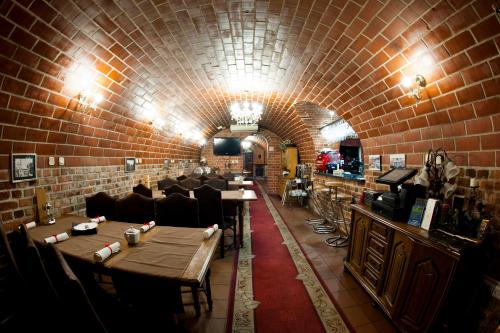 a restaurant with a brick wall and tables and chairs at Hotel Warmia Spa in Braniewo