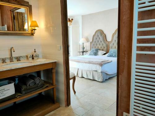 Le Clos Bel Ami في Bec-de-Mortagne: غرفة نوم بسرير ومغسلة ومرآة