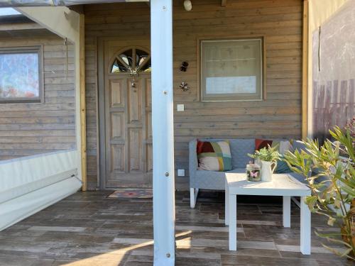una veranda con panchina, tavolo e porta di NEUTRINO VENDÉGHÁZ a Zánka