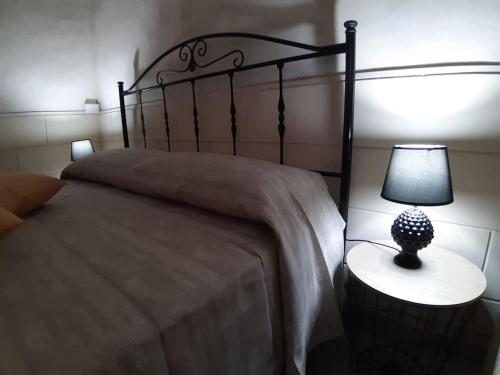una camera con un letto e una lampada su un tavolo di La Casa delle Zie a Maglie