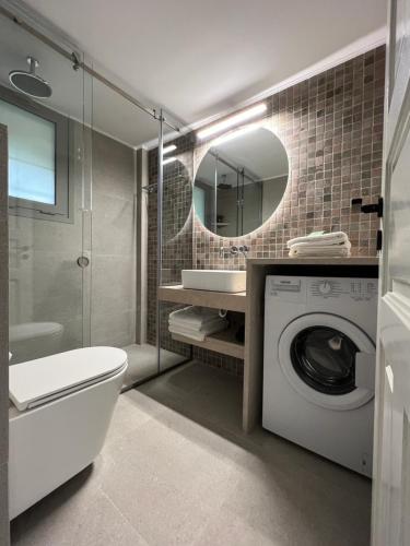 a bathroom with a washing machine and a mirror at Panagea Holiday Apartments in Kitriaí