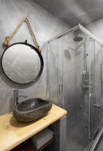 a bathroom with a stone sink and a shower at Sunray Lodgings in Kamari