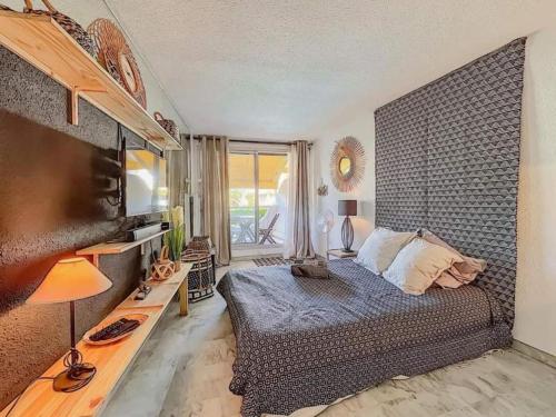 a bedroom with a bed and a large window at Le soupir des palmiers. Idéal couple, piscine, mer in La Grande-Motte