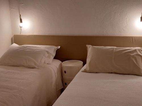 埃爾瓦什的住宿－Estúdio na Carreira，酒店的客房内设有两张带白色枕头的床。