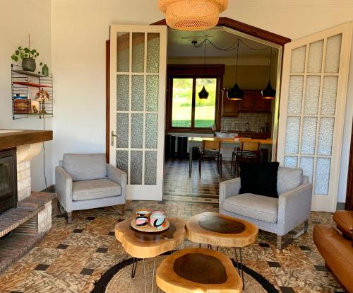sala de estar con 2 sillas y mesa en Gezellige villa met open haard en zonnige tuin., en Doische