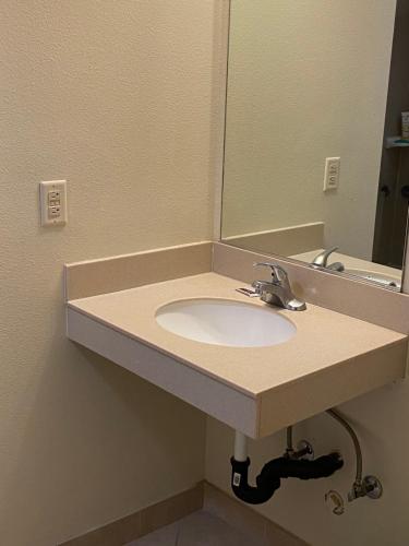 W łazience znajduje się umywalka i lustro. w obiekcie Lone Pine Budget Inn w mieście Lone Pine