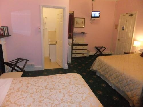 a hotel room with two beds and a bathroom at Elgin Villa in Bath