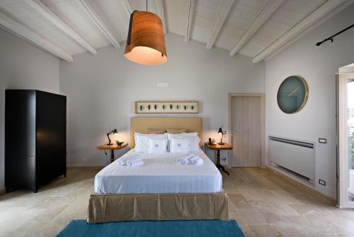 1 Schlafzimmer mit einem großen weißen Bett und 2 Tischen in der Unterkunft Poggio Leano Boutique Hotel in Donnalucata