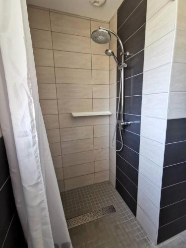 une douche avec pommeau de douche dans une salle de bain dans l'établissement La clé des champs, à Clam