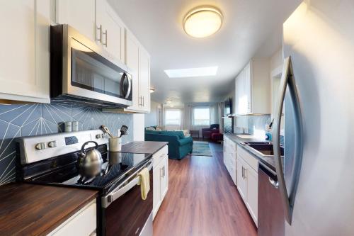 a kitchen with white cabinets and a stove top oven at Alsea Sands in Waldport
