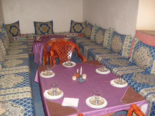 a living room with a couch and a table with wine glasses at Kasbah tifaoute ait Ben haddou in Aït Ben Haddou