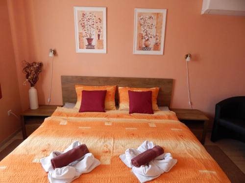 - une chambre avec un grand lit et 2 serviettes dans l'établissement Völgy Apartman, à Eger