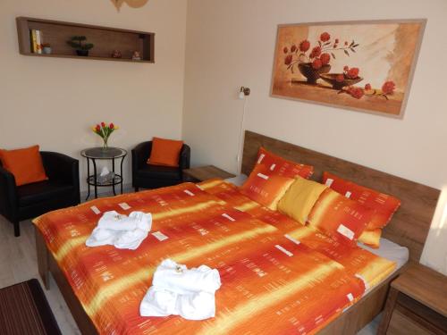 - une chambre avec un lit et des serviettes dans l'établissement Völgy Apartman, à Eger