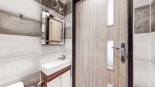 a bathroom with a toilet and a sink and a door at Apartament Dubaj in Bytom