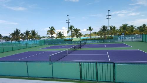 due campi da tennis con palme sullo sfondo di Alquiler de Apartamento en Playa Blanca a Río Hato