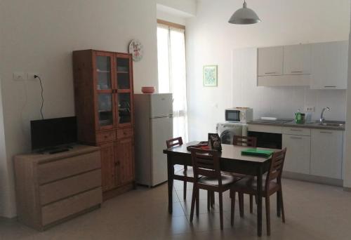 a kitchen with a table and chairs and a refrigerator at Casa Minù in La Spezia