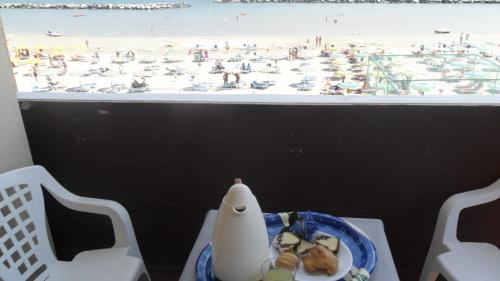 stół z talerzem jedzenia i widokiem na plażę w obiekcie Hotel Giordano Spiaggia w Rimini
