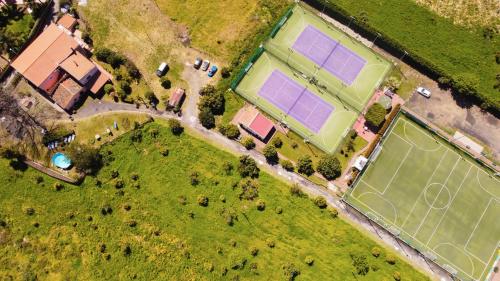 an overhead view of two tennis courts on a field at Villa Nadira in Giardini Naxos