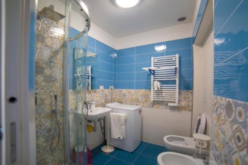 uma casa de banho azul com um lavatório e um WC em ELISA Dependance Centro em Vietri