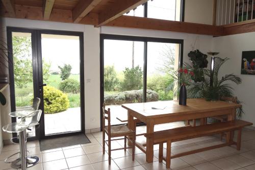 d'une salle à manger avec une table, des chaises et des portes coulissantes en verre. dans l'établissement Maison sur la colline cheminée WIFI proche Thermes, à Aubin