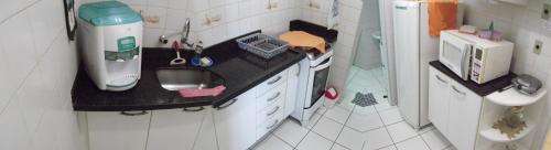 a small kitchen with a counter and a sink at Apartamento inteiro para até 5 pessoas in Campinas
