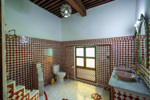 a bathroom with two sinks and a toilet in it at Riad Le Moucharabieh in Fès