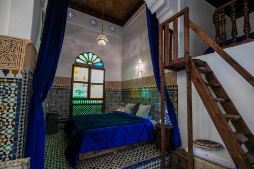 a bedroom with a bed and a staircase in a room at Riad Le Moucharabieh in Fès
