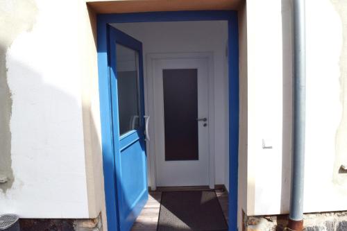 a blue door leading into a hallway at Gut Kuhfs in Großzössen