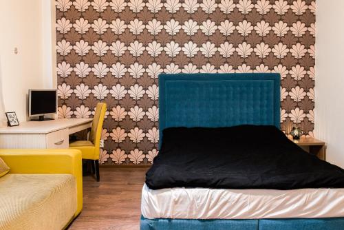 a bedroom with a bed with a blue headboard and a desk at Apartament Ultracentral, Piata Romana in Bucharest