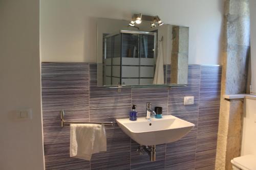 a bathroom with a sink and a mirror at Appartamento Le Tre Palme in Frigintini
