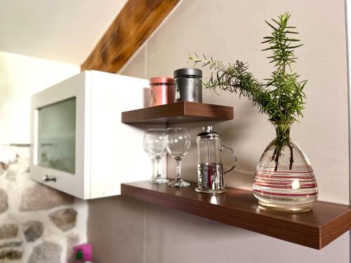 a shelf with a vase and glasses on a wall at HealthyStudio512 Apartments in Kotor