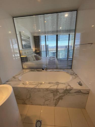 黄金海岸4 Bedroom Huge Sub Penthouse Oracle Level 31 Magnif VIEWS 260m2 Family Skyhome Sleeps 8 Adults and 2 Children, Sofa Bed Portacot, High Chair Central to Everything Resort Skyhome 5 STAR Luxury的一间带大窗户和浴缸的浴室