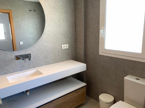 W łazience znajduje się umywalka i lustro. w obiekcie Beautiful apartment with pool near the beach w mieście Oliva