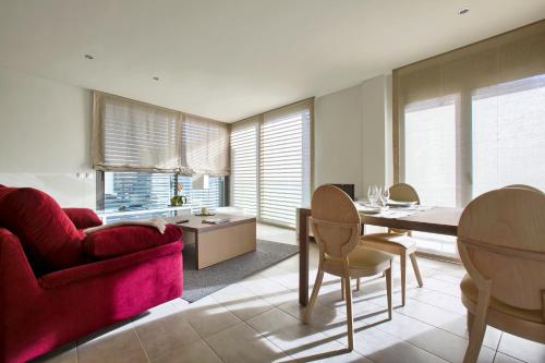 a living room with a red couch and a table at Apartaments Terraza Figueres in Figueres