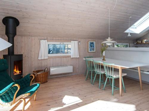 a living room with a table and chairs and a fireplace at 6 person holiday home in Ulfborg in Ulfborg