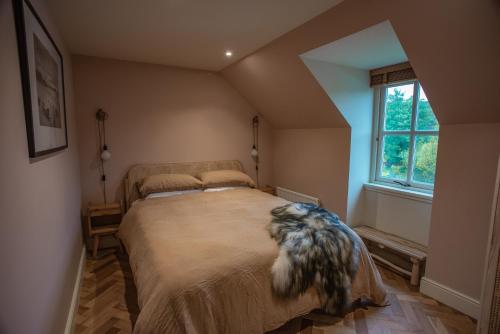 a bedroom with a bed with a dog laying on it at The Coach House at The Albannach in Lochinver