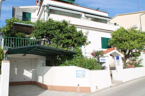 a white building with a balcony on top of it at Adria Apartments in Podgora