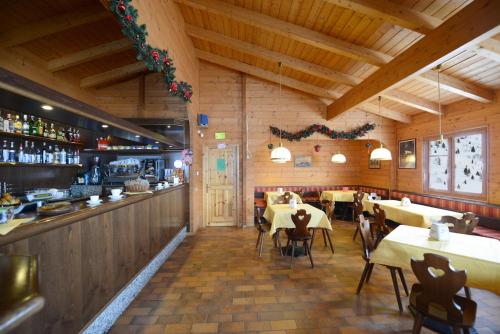 a restaurant with tables and chairs and a bar at Savoia Hotel in Passo del Tonale