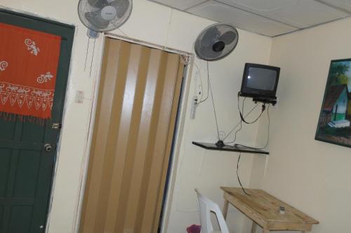 a room with a door and a tv on the wall at Hostal Nicaragua Guest House in Managua