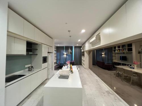 een keuken met witte kasten en een lange witte tafel bij Platinum Suites KLCC By Citybox in Kuala Lumpur