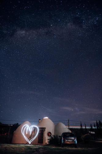 a heart lit up in front of a building at night at Valle de Domos - Minas in Minas