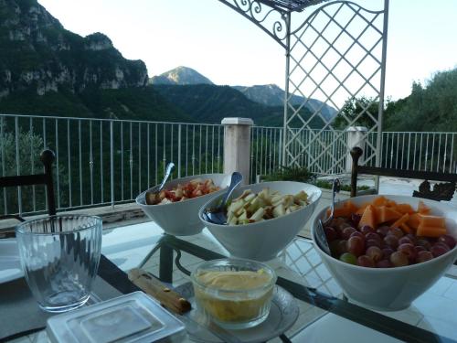 una mesa cubierta con tazones de fruta en la parte superior de un balcón en Le Mont d'Olivine, en Utelle