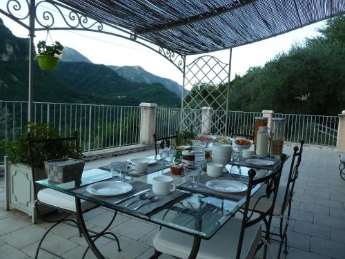 ein Tisch mit Tellern und Besteck auf einer Terrasse in der Unterkunft Le Mont d'Olivine in Utelle