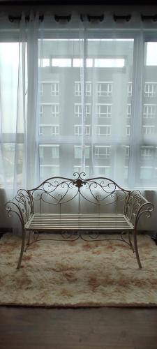 a metal bench sitting in front of a window at Bukit Rimau Instagrammable 2 Bedroom Apartment With Pool View up to 5 PAX in Shah Alam