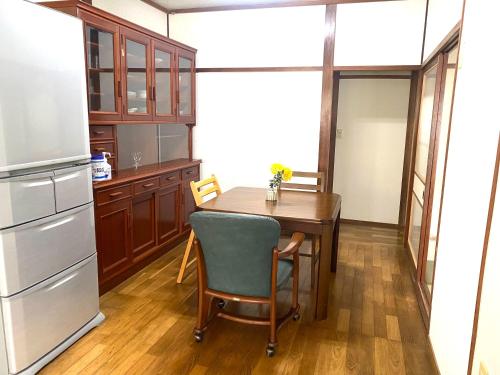 una cucina con tavolo e frigorifero di 鉄道と山の見える家 a Yufu