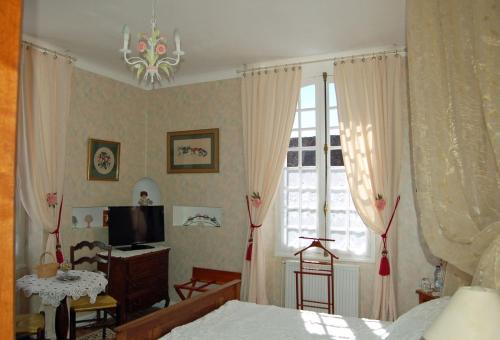 1 dormitorio con 1 cama, TV y ventana en La Maison d'Antan, en Arzacq-Arraziguet