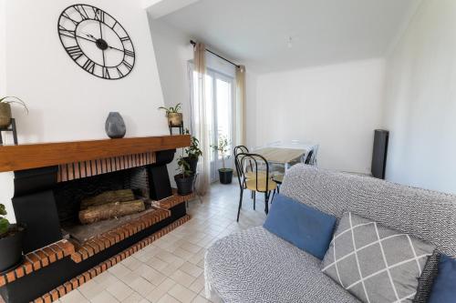 a living room with a fireplace and a clock on the wall at Chambre hote - Dormir comme à la maison - in Châteaubriant